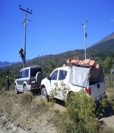 Vehículos y equipo de trabajo junto a postes eléctricos
